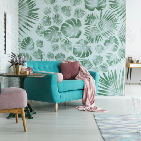 tropical wallpaper accent wall next to white painted brick walls with blue mid-century modern furniture in the foreground