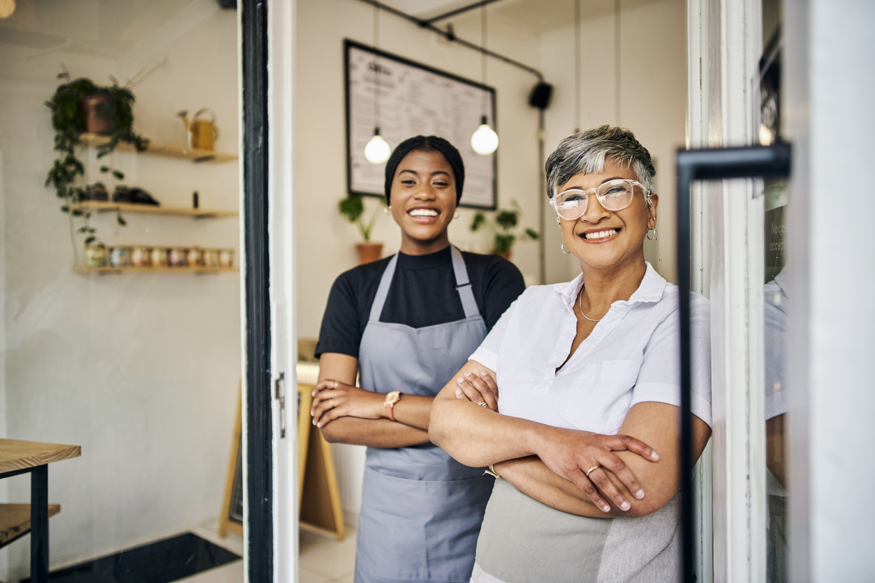 Coffee shop, senior woman manager portrait with barista feeling happy about shop success. Female server, waitress and small business owner together proud of cafe and bakery growth with a smile