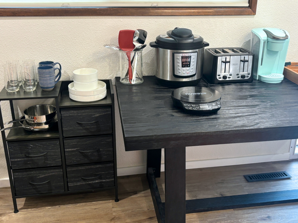 An image of a temporary kitchen setup, complete with an instant pot, toaster, and hot plate.